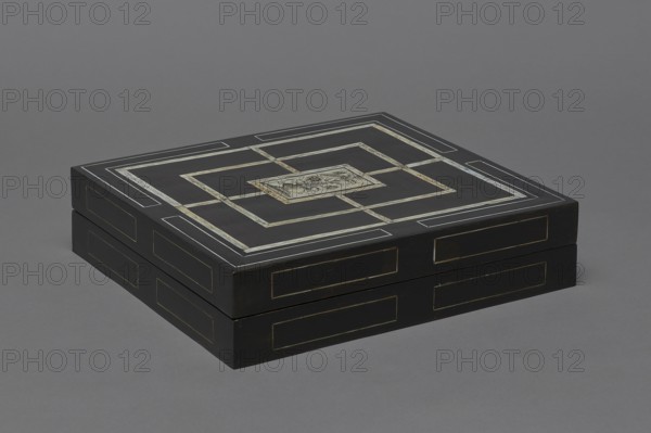 Chess, mill and backgammon box by, games; flower vases; chess; ; plant decoration; baroque style; landscapes; backgammon; animals; birds; checkers party game; 1680s, France; furniture; equipment; game furniture; height 9 cm, width 37 cm, depth 32.8 cm, A rectangular black box with decorative inlaid geometric borders sits on a gray surface; the top shows concentric rectangular patterns with lighter inlaid strips and a central lighter rectangular panel featuring a floral or botanical motif, and the box sides have framed inlaid panels. The visible colors are black, gray, cream, and subtle beige tones.