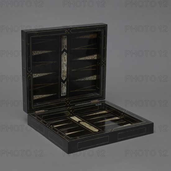 Chess, mill and backgammon box; creator, games; flower vases; chess; ; plant decoration; baroque style; landscapes; pre-war collections; backgammon; animals; birds; checkers party game; 1680s; France; furniture; equipment; game furniture; height 9 cm; width 37 cm; depth 32.8 cm, A rectangular hinged box is open to display its interior, showing a glossy black surface with decorative inlaid panels and narrow triangular motifs in a lighter off-white or cream color, accented by thin gold lines and geometric borders; the exterior and interior edges are black with gold trim, and the background is a uniform gray.