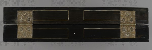 Chess, mill and backgammon box; maker, games; flower vases; chess; ; plant decoration; Baroque style; landscapes; backgammon; animals; birds; checkers party game; 1680s; France; furniture; game furniture; height 9 cm; width 37 cm; depth 32.8 cm, A rectangular dark wooden object shown from above with a horizontal hinge in the center, featuring a pair of ornate metal hinge plates on each side that are metallic gold with engraved decorative patterns and round screw heads; the wood surface is predominantly black and dark brown with lighter narrow inlaid rectangular borders, and the background is a uniform light gray.