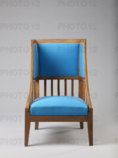 Armchair Berzera with a slender backrest and sides equal in height that arch upwards to form ears; angular frame elements. Front legs converge while rear legs arch outward. Narrow, straight frame; trapezoidal seat in the form of a removable cushion on springs. The upper part of the sides and the backrest, slightly wider at the top, are upholstered; the lower part is filled with vertical slats. Frame elements are additionally connected with single pegs. Ca. 1820; possible places of origin: Warsaw, Vienna, Lesser Poland. Piece of furniture seating, height 86.5 cm, width 54.8 cm, depth 61.8 cm., A wooden chair with a straight back and slatted sides upholstered in bright blue fabric on the seat and back panels, the wood showing a warm brown tone with visible grain, set against a plain light gray background; the upholstery has a decorative trim along the inner edges and the chair rests on tapered wooden legs.
