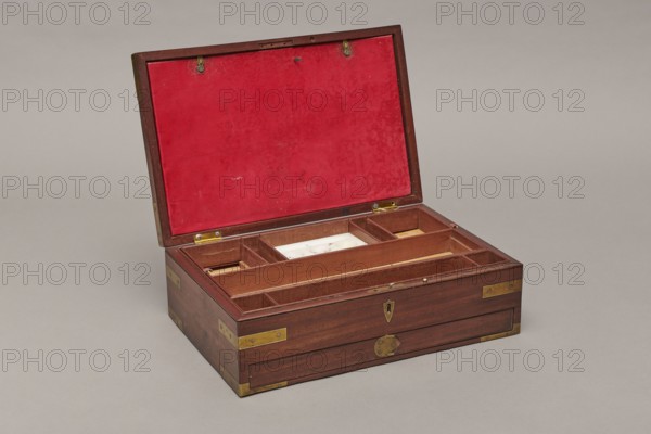 Painter's cassette, Travel painter's cassette, cuboid mahogany box with corners of body and lid reinforced with recessed brass sheets. Bottom of body contains a drawer secured by a brass pin inserted from above. Interior front has a row of compartments wider in the middle, square on the sides; behind them two removable containers — an upper one with five compartments three wide, separated by narrow ones and a lower flat container with round sockets for faience paint vessels. Contains a steel pen holder; nine paintbrushes three flat, six round, various numberings; including Pelikan and Z. Dudek Warszawa; five cylindrical glass containers; eight porcelain bowls signed Cmielów / MADE / IN POLAND; a set of watercolors 54 pans; a stick of black Chinese ink; and a resin stick. Bottom backed with green cloth. Inside lid is a cardboard and red leather file folder closed with two small brass bolts. Mortise lock with two sliding hook bolts; brass elongated-disc lock plate. Brass and slate hinges...