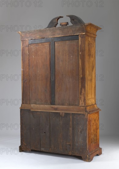 Sideboard, gift, architectural elements, plant decoration, two-part sideboard with chamfered and concave front corners, wavy front and straight sides, three-drawer base and top closed with double doors, supported on console legs; veneered with patterned walnut, inlaid with ribbon motifs, polished. Tops of the upper section framed by richly profiled cornices, the upper one with a flat roof and a volute cornice with a central corbel. Top leaves have a wavy design creating a crossbow-like outline, mirrored by the narrow cornice above. Sides of both bodies, doors and drawer faces framed with a ribbon and cross-shaped frame. Three shelves not original inside. Construction of both bodies, drawer faces and door leaves is board-like; back framed with two panels; bases board-like. Rims fastened to sides with wedges. Steel applied locks; single-bolt drawer locks; double-bolt door locks. Steel pintle hinges; single-bolt steel-brass latches. Brass pull-style drawer handles. Brass openwork asymmetr...