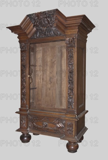 Wardrobe, provenance, putti; baroque style; coats of arms; plant decoration; lion masks; personifications of the seasons: Spring, Summer, Autumn, Winter; 1710–1730; Gdansk, Royal Prussia; piece of furniture storage; height 200 cm, width 124 cm, depth 62 cm, The image shows a large carved wooden cabinet standing against a plain light gray background. The cabinet is a dark brown wood with a rich grain and features ornate carved details along the top, sides, and lower front, including floral and scroll motifs and a central carved crest at the cornice. The interior of the cabinet is visible and shows rawer, lighter brown wood panels. The cabinet rests on rounded bun feet that are a darker brown and glossy, and it has decorative molding and raised panels on its sides and base. Several carved vertical panels flank the cabinet opening, and the top has layered cornice moldings in matching dark brown wood. The overall visible colors are shades of brown and the neutral light gray of the backgrou...