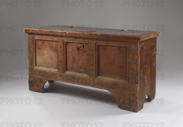 Chest, Gothic style, floral and geometric ornament, repossession/purchase provenance noted, chest with straight sides and front forming console legs at the bottom, flat lid, decorated on the pseudo-frame of the front with engraved dry thistle motif on a darkened background. Panels and sides smooth, lid framed on sides and front with profiled frames forming the rim. Board walls, back and front attached to body, fastened with dowels. Interior on the left side of the box. Steel fittings secondary — steel applied lock without a cup, strap-eye hinges, fastened with forged nails. Dated 1500–1520. Place of origin possibly Bavaria, Lesser Poland, Central Europe. Furniture; storage furniture. Height 80.5 cm, width 159 cm, depth 60 cm., A wooden chest with a rectangular top and paneled front, showing a worn brown finish with areas of lighter and darker brown; the front has three recessed panels separated by vertical carved stiles and a carved horizontal band along the base with an interlacing pa...