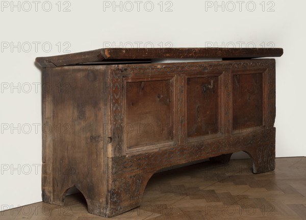 Chest, Gothic style, floral and geometric ornament, repossession, pre-war collection, chest with straight sides and front forming console legs at the bottom, with a flat lid, decorated on the pseudo-frame of the front with an engraved decoration featuring a dry thistle motif with a darkened background. Panels and sides are smooth, without decoration. The lid is framed on the sides and front with profiled frames forming the rim. Board walls, back and front are attached to the body, fastened with dowels. Inside, on the left side of the boxes. Steel fittings, secondary — steel lock, applied, without a cup, strap-eye hinges, fastened with forged nails. Date: 1500–1520. Place of origin: Bavaria, Lesser Poland, Central Europe. Furniture; storage furniture. Dimensions: height 80.5 cm, width 159 cm, depth 60 cm., A wooden chest with a hinged top shown slightly open, displaying a worn surface with visible grain and knots; the front has recessed rectangular panels framed by carved borders with a...
