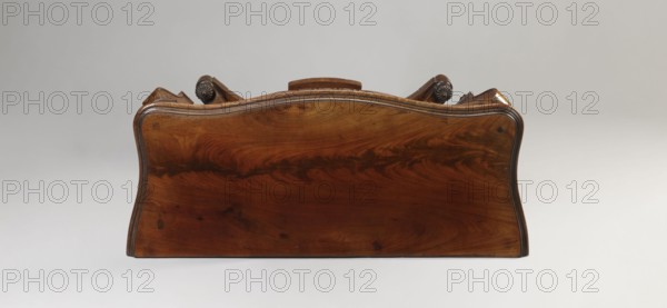Console, purchase, Vilnius - gifts and purchases 1945-1947, Biedermeier and Louis Philippe styles, rectangular carved mahogany-veneered console on four angular legs mounted on a platform with a wavy outline; front legs strongly curved, rear legs straight and flattened, with bases and capitals. Entire piece polished. Platform supported by four low turned legs. Lower leg sections formed of channel sections decorated at top and bottom with knobby pinnacles. Wide frame repeats concave-convex shape of top, rounded at front corners, wavy-cut at bottom, framed with a half-cylinder; front frame forms face of the drawer. Top has a profiled edge, connected to frame with cube side panels. Drawer contains two rows of compartments inside; small corner ones in front row have rosewood covers. Drawer secured by a single-bolt mortise lock. Dated 1835–1850, Vilnius place of origin?, piece of furniture — table; height 82 cm, width 107.2 cm, depth 45 cm., A wide wooden headboard with a smooth, polished su...