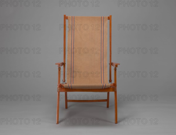 Deckchair, Polish Timber Industry, Czerski and Jakimowicz Lviv; furniture factory; 1929–1939,  furniture factory author; lounge furniture, beach furniture, garden furniture, folding. DECKCHAIR constructed from two different sized rectangular frames: the backrest smaller and the seat larger, connected by hinges, with canvas stretched over them. The frame elements with the exception of the turned rear leg connector and the doubled front seat stile are angular. The seat frame is supported on its shorter sides by two folding legs connected by a connector, the front extended into armrest supports. The armrests have hinges adjustable in three positions. Salmon-colored canvas fabric with vertical orange stripes framed by narrow blue stripes; attached to the underside of the upper backrest frame and the rear seat frame, sandwiched between the two front seat frames. Originally the deckchair was equipped with a separate footrest. 1938–1939, Lviv; piece of furniture, seating furniture. Height 84....