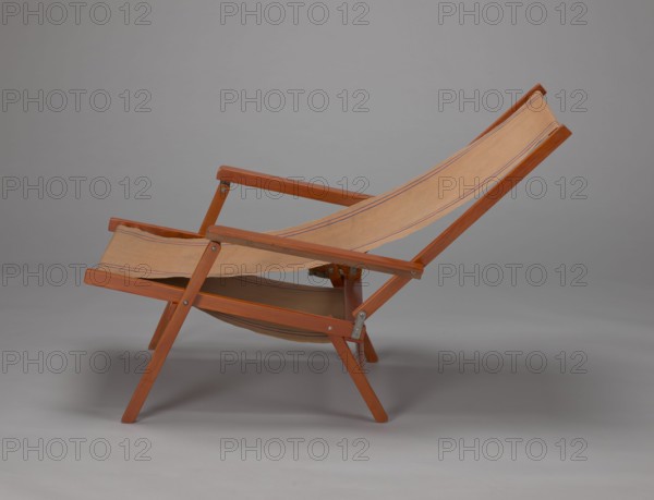Deckchair, Polish Timber Industry, Czerski and Jakimowicz furniture factory; 1929–1939,  furniture factory author, lounge furniture, beach furniture, garden furniture. Folding deckchair constructed from two different-sized rectangular frames: the backrest smaller and the seat larger, connected by hinges, with canvas stretched over them. The frame elements with the exception of the turned rear leg connector and the doubled front seat stile are angular. The seat frame is supported on its shorter sides by two folding legs connected by a connector, the front extended into armrest supports. The armrests have hinges adjustable in three positions. Salmon-colored canvas fabric with vertical orange stripes framed by narrow blue stripes; attached to the underside of the upper backrest frame and the rear seat frame, sandwiched between the two front seat frames. Originally the deckchair was equipped with a separate footrest. 1938–1939. Lviv place of origin. Piece of furniture, seating furniture. H...