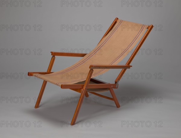 Deckchair, Polish Timber Industry, Czerski and Jakimowicz Lviv; furniture factory; 1929–1939,  furniture factory author, lounge furniture, beach furniture, garden furniture. Folding deckchair constructed from two different sized rectangular frames: the backrest smaller and the seat larger, connected by hinges, with canvas stretched over them. The frame elements with the exception of the turned rear leg connector and the doubled front seat stile are angular. The seat frame is supported on its shorter sides by two folding legs connected by a connector, the front extended into armrest supports. The armrests have hinges adjustable in three positions. Salmon-colored canvas fabric with vertical orange stripes framed by narrow blue stripes; attached to the underside of the upper backrest frame and the rear seat frame, sandwiched between the two front seat frames. Originally the deckchair was equipped with a separate footrest. 1938–1939, Lviv; piece of furniture, seating furniture. Height 84.2...