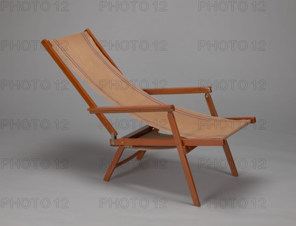 Deckchair, Polish Timber Industry, Czerski and Jakimowicz Lviv; furniture factory; 1929–1939,  furniture factory author, lounge furniture, beach furniture, garden furniture, folding deckchair constructed from two different sized rectangular frames: the backrest smaller and the seat larger, connected by hinges, with canvas stretched over them. The frame elements with the exception of the turned rear leg connector and the doubled front seat stile are angular. The seat frame is supported on its shorter sides by two folding legs connected by a connector, the front extended into armrest supports. The armrests have hinges adjustable in three positions. Salmon-colored canvas fabric with vertical orange stripes framed by narrow blue stripes; attached to the underside of the upper backrest frame and the rear seat frame, sandwiched between the two front seat frames. Originally the deckchair was equipped with a separate footrest. 1938–1939, Lviv, seating furniture, height 84.2 cm, width 58.5 cm, ...