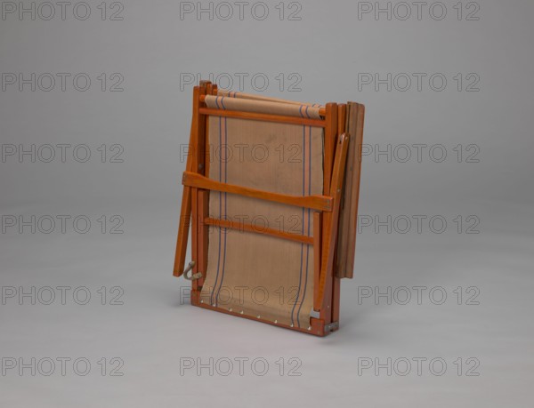 Deckchair, Polish Timber Industry, Czerski and Jakimowicz Lviv; furniture factory; 1929–1939,  furniture factory author; lounge furniture, beach furniture, garden furniture. Folding deckchair constructed from two different-sized rectangular frames: the backrest smaller and the seat larger, connected by hinges, with canvas stretched over them. The frame elements except for the turned rear leg connector and the doubled front seat stile are angular. The seat frame is supported on its shorter sides by two folding legs connected by a connector, the front extended into armrest supports. The armrests have hinges adjustable in three positions. Salmon-colored canvas fabric with vertical orange stripes framed by narrow blue stripes; attached to the underside of the upper backrest frame and the rear seat frame, sandwiched between the two front seat frames. Originally equipped with a separate footrest. 1938–1939, Lviv; type of seats/place of origin. Piece of furniture, seating furniture; height 84...