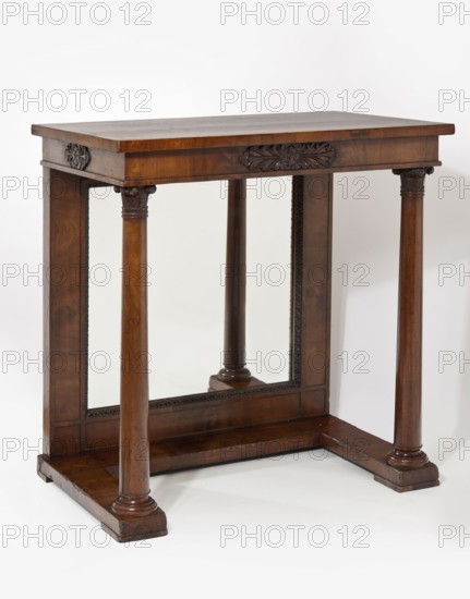 Console, revindication provenance, rosettes ornament, floral decoration, furnishings of representative buildings of the Republic of Poland 1918–1939, Biedermeier style, kimation ornament, columns architectural, rectangular, mahogany. Console supported at the front by a pair of ball-shaped supports, at the back by a mirrored wall. Supports mounted on a platform in the form of a frame open at the front, on four low cube feet. Frame simple, enclosed at the bottom by a petal, decorated at the front with a carved appliqué of two symmetrically connected palmettes. Carved Corinthian column heads. Dated 1820–1840, Warsaw. Furniture, table. Height 80.3 cm; width 76.2 cm; depth 49.4 cm., A wooden console table with a rectangular top and a carved decorative motif on its front apron, supported by several rounded columns set on a broad plinth base; the wood shows rich brown tones with darker carved accents and lighter grain variations, and there is a mirrored panel set into the back frame reflectin...
