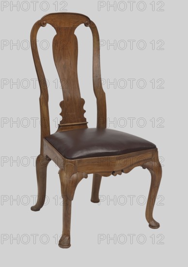 Chair, Baroque style, walnut. CHAIR with a trapezoidal seat with an inset cushion and a high openwork backrest with a central board, on four cabriole legs with cushion feet. Legs are significantly widened in the upper section, arcing into the front frame, which is wavy-cut at the bottom and bulges. Seat cushion upholstered in leather. Straight side frames. Side rails of the backrest are concave on the sides and arched at the top; the upper rail is finished with volutes on the sides, connected to the central board with the outline of an elongated vase. In the type of English seats from the Queen Anne period, ca. 1720–1735, England . Seating furniture; height 106.5 cm, width 56.5 cm, depth 56.5 cm., A wooden chair with a curved, ornate backrest and carved decorative elements, featuring a dark brown leather or leather-like padded seat; the wood shows medium brown and lighter brown grain tones with curved legs and sculpted apron details, set against a light gray background.