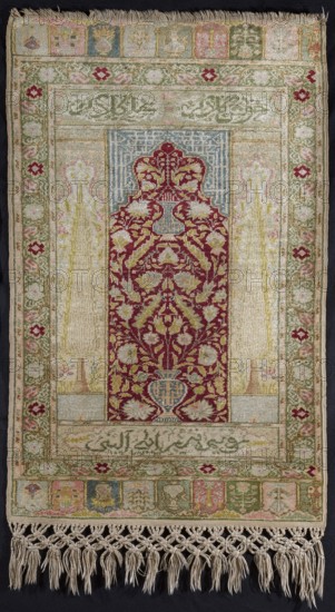 Giordes-type prayer rug, In the central field a red semicircular mihrab arch with offsets; in the mihrab niche a hanging lamp at the top and a vase with flowers and lanceolate leaves at the bottom. Stylized Arabic inscription inside the lamella and vase and in the corners of the central field, with Turkish text in Arabic script above and below the mihrab arch. Cypress trees flank the niche. Three-band border: inner and outer bands beige with a green geometric pattern, central band decorated with red and pink flowers. Niches at top and bottom decorated with vases and flowers. Colors: cherry red, white, and green backgrounds; light green and pink ornaments. Symmetrical knots. Inscription in Naschi script in Turkish in a rectangular field at the top reading Welcome! Be greeted. Other inscriptions undecipherable. Giordes knotting, knot density approx. 2500 per 1 dm². 18th century, Turkey. Height 86 cm, width 54 cm., A rectangular woven textile with tasseled fringe along one short edge, fea...
