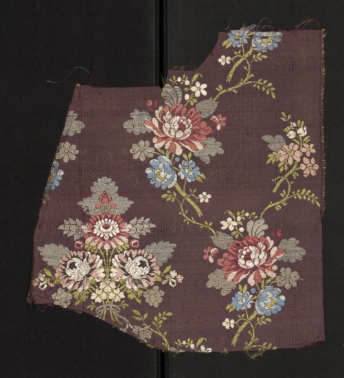 Fabric fragment, fragments of silk fabric, patterned with a symmetrical composition of bouquets and sprigs of multicolored stylized flowers. Gros de Tours background with liseré; pattern brocaded with colorful threads: green, white, blue, light and dark red, pink; silver threads braided tied in rows. Reported dimensions larger than preserved fragment. Edge width: 0.3 cm. Second half of the 18th century, France. Height 34 cm, width 38 cm., A piece of woven fabric with a dark purple background laid against a black surface, decorated with a repeating floral pattern featuring a few large, stylized blossoms in shades of red and pink, several smaller flowers in blue and pale pink, and clusters of leaves in muted green and gray; the floral motifs are arranged on curving stems and accompanied by additional small floral sprays, and the fabric edges are uneven and slightly frayed.