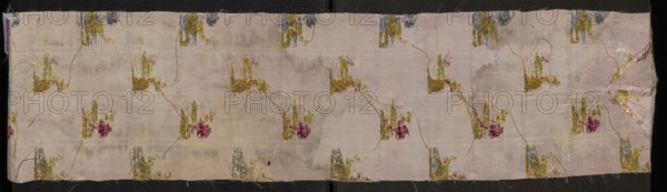 Fragment of pale pink silk fabric brocaded with colorful threads and silver thread. Brocade threads: light green, pink, pale pink, light brown, white, blue, pale purple, cherry red, silver. The fabric is divided into horizontal silver stripes forming the basis for miniature landscapes placed alternately: a tuft from which a tree grows, smaller silhouettes of trees in the background, and a fragment of ruins overgrown with vegetation. These landscapes are separated by vertical stripes and floral bouquets woven from the background. The fabric background is a weave derived from linen a type of rep. 2nd half of the 18th century, France. Height 106 cm, width 23 cm., A long rectangular piece of fabric with a pale pink background shows a repeating floral motif connected by thin curving stems; the motifs include shades of olive green, mustard yellow, muted blue, and deep rose, with hints of beige and cream where the base shows through, and the fabric surface displays areas of wear and faint dis...