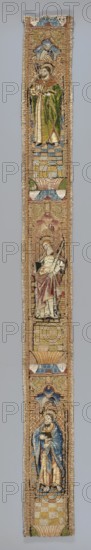 Fragment of embroidery, embroidery, Goluchów Greater Poland Voivodeship, saints: Catherine of Alexandria ca. 282–ca. 300, Simon, Thomas the Apostle; liturgical vestment fragment. One of eight fragments of a liturgical vestment with three figures of saints enclosed in architectural frames: top — a saint with a book and an abbot's cross; middle — a saint with a book and an executioner's sword; bottom — a saint with a book and a sword St. Paul. Embroidery and appliqué: figures appliquéd on linen canvas; embroidery with gold thread laid and stitched with colored silks or nue and silks with a flat split stitch. Background, architecture, and floor on a string backing. Colors: gold, red, blue several tones, Indian rose, and green several tones. 1st half of the 16th century, Netherlands. Height 112 cm, width 10 cm., A narrow vertical textile panel showing a series of three haloed standing figures arranged one above the other, each set within decorative niches and separated by patterned bands; ...