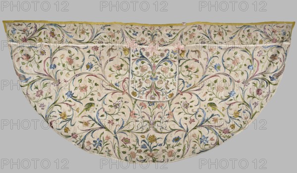 Cope, Cope made of embroidered silk fabric with linen lining; the silk backing of the embroidery has crumbled and the embroidery is preserved thanks to a linen backing hidden beneath the silk. Embroidered decoration entirely covers the surface with a pattern of leafy tendrils and flowers roses, tulips, carnations. Silhouettes of birds — peacocks, parrots, turkeys, and others — adorn the branches. Edges trimmed with yellow silk braid; hood features preserved bows of pink silk ribbon. 18th century, Silesia. Liturgical vestment. Dimensions: length 139 cm, width 287 cm., A semicircular textile with an off-white background densely covered in an allover floral and foliate embroidery, showing a symmetrical swirling vine pattern with a few large stylized flowers and several smaller blossoms in pastel pink, pale blue, soft yellow, muted green, and touches of purple and gold; the vines and leaves are mainly green with accents of blue and purple, and there are a few bird motifs embroidered in gre...