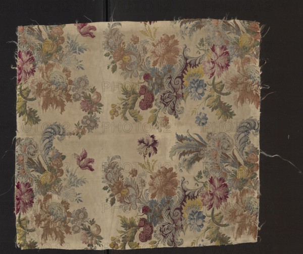Fabric fragment, silk, 18th century, France. Fragment of patterned silk fabric with floral motifs, white grosgrain background, pattern brocaded with colorful threads in several shades of blue, navy, turquoise, browns, greens, pinks, reds, silver and yellow. Preserved pattern. Dimensions reported: 40 x 27 cm also listed height 45 cm, width 50 cm. Purchase, A square of fabric with a floral woven pattern lies on a dark background; the fabric has a light beige base with a repeating motif of ornate flowers and leaves in colors including muted pink, dusty rose, yellow, pale blue, seafoam green, olive green, deep purple, and soft brown, with some areas of darker maroon and faded blue; the flowers and foliage form swirling bouquets and clusters across the surface, and there are scalloped ornamental flourishes and feathery leaf shapes interspersed; the fabric edges are slightly frayed and uneven, and loose threads extend from the sides.