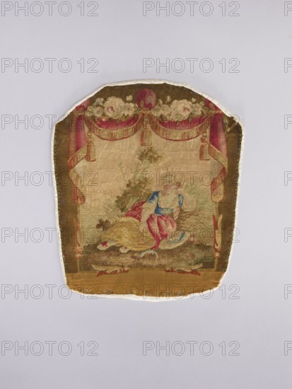 Three tapestry armchair covers, varietals, provenance, flowers, floral ornaments, genre scenes, interior furnishings, garlands, furniture upholstery, decorative fabrics; three tapestries: a boy sitting on a hillock playing a flute, b boy watering flowers, c girl sitting on a hillock; 2nd half of the 18th century; Aubusson; fabrics; height 27.5 cm, width 35 cm., A fabric panel with a rounded top and straight bottom showing a woven scene in muted colors; the panel features a decorative border with draped curtains and floral swags in shades of red, pink, cream, and brown, framing a central pastoral scene. Within the scene a reclining figure wearing garments in blue, pink, and yellow is set against an earthy background of greens, browns, and beige with hints of darker green foliage behind. The overall color palette includes brown, beige, cream, pink, red, blue, yellow, and green, and the panel edges show a lighter fabric backing in off-white.