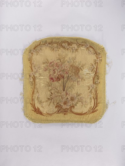 Two tapestry armchair backrest upholsteries and one sofa upholstery, unknown author, varietal, flowers, floral ornaments, furniture upholstery, interior furnishings, decorative fabrics, tapestries; a, b armchair upholstery with a bouquet of flowers in the center, surrounded by a frame of acanthus flowers and leaves; c sofa upholstery with a spreading bouquet of flowers surrounded by a frame with acanthus flower and leaf motifs. Colors: sandy background, olive, pink, red, ochre, blue, and green ornaments. 18th/19th century, France; fabrics; height 64 cm, width 62 cm., A square textile fragment with rounded corners lying on a pale background, showing a woven floral central design in faded tones of gold, beige, pink, green, and brown, surrounded by a decorative border in similar gold and brown shades; the fabric edges are frayed and worn, with visible stitched seams and areas where threads have come loose, and the surface displays subtle variations in sheen and some worn patches.