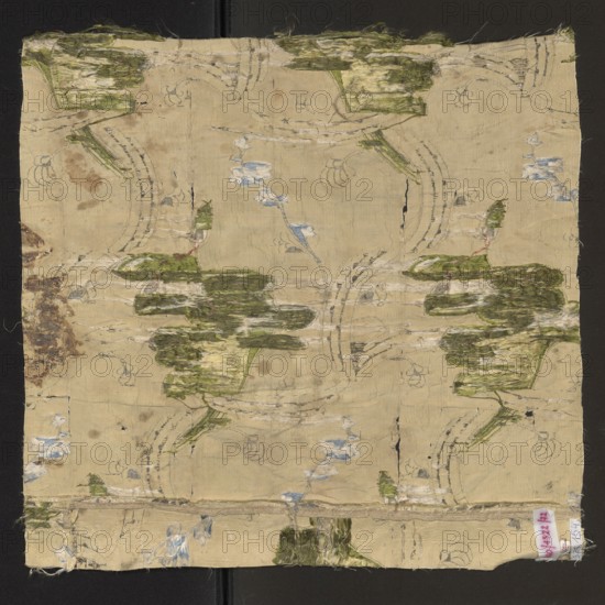 Fabric fragment, fabrics, fragments of silk fabrics, patterned fabrics, floral patterns, Weave structure: Gros de Tour background cream warp and weft; pattern - liseré subaperture; brocade wefts: silver lamellar, green, celadon, brown, cherry. Pattern: vertically winding silver ribbon, entwined with a sprig of green-silver flowers with brown-cherry centers. The vertical arrangement is broken in places, creating a network, by the same horizontally winding silver ribbon. Colors: cream background, motifs – green, celadon, burgundy, brown. Width: edge: 0.7 x 0.8; repeat: approx. 50 x 26 cm. 18th century, France. Height 50 cm, width 48 cm., A square piece of worn fabric laid flat against a dark background, showing an overall pale beige base with faded printed outlines and worn areas; there are several patches of frayed green threads forming irregular horizontal shapes, patches of pale blue thread in small clustered floral-like shapes, and areas of off-white and dirty beige wear. The fabric ...