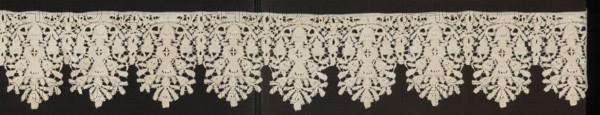 Lace fragment, floral ornaments. Lower edge serrated. In each oval there is a vase of flowers. Flower crowns overlap the serrations. Joined with spiderwebs, so-called Van Dyck. Date: 1630–1650. Place of origin: Flanders. Material: lace. Dimensions: length 200 cm, width 13.5 cm., A horizontal strip of lace with a repeating scalloped pattern is visible against a dark background; the lace is a pale off-white or cream color and features a series of arch-like motifs connected along a straight top edge, each arch enclosing a symmetrical floral or fern-like pendant that hangs down with layered, leaf-shaped elements and openwork details, and the dark background shows through the lace openings creating contrast between the light lace and the deep dark backdrop.