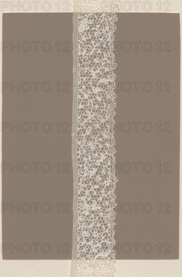 Lace fragment, needle lace, delicate pattern of plant tendrils and numerous spans, in the style of Italian punto a vermicelli lace. Lower edge with fine serrations; upper edge straight with a sewn-on bobbin insert and a double ladder. 17th–18th century, France. Lace, length 86 cm, width 6 cm., A vertical strip of delicate lace with an open, irregular floral-like pattern runs down the center of the image, bordered on one side by a narrow, more tightly woven edge; the lace is off-white or cream colored. Behind the lace is a large rectangular panel in a muted taupe or grayish-brown color that fills most of the frame. Around the outer edges of the image is a wider border of a light beige or cream paper texture. The overall composition shows the contrast between the intricate off-white lace, the solid taupe rectangle, and the light beige surrounding border.