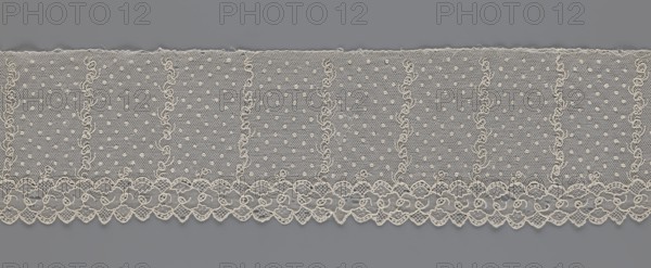 Lace fragment, strip with a serrated edge on one side and an edge-type ornament on the serrated side; above are narrow strips of stylized plant ornament with an onion-shaped flower motif and, between them, small round dots in a regular projection against a mesh background. Lace, fabric; 1st half of the 19th century, Europe. Width 12.5 cm, length 210 cm., A band of delicate lace in off-white is laid against a flat gray background, showing a repeating pattern with a scalloped lower edge and a straight upper edge; the lace fabric has a fine hexagonal net ground dotted with a few raised circular motifs and separated into vertical sections by a few sinuous embroidered lines, while the scalloped border features a repeating floral and looped motif with denser embroidery and openwork areas.