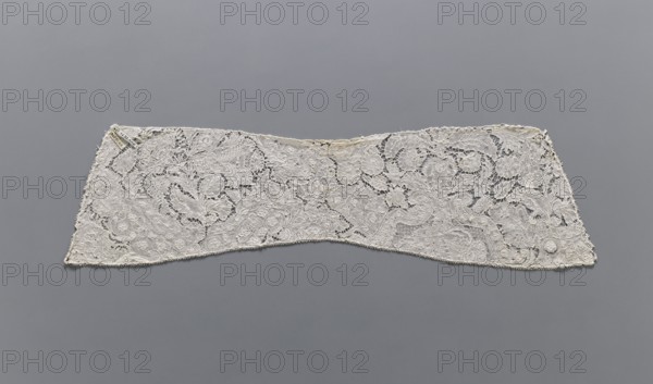 Collar, maker, Kublicki Piottuch, Alfred 1861–1945. Lace clothing accessory collar, early 18th century, Binche. Background fond de neige, de brides and others. With large and small floral motifs, ribbons and candelabra. Lace, width 15 cm, length 57 cm., A long, narrow piece of lace fabric displayed flat against a gray background, showing an intricate openwork pattern with floral and foliate motifs and a scalloped lower edge; the lace appears in shades of off-white and cream with subtle darker beige areas where the weave is denser, and the background is a uniform mid-gray.