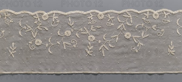 Lace fragment, Lace, unknown provenance. Plant ornaments. The lower edge is gently serrated with flat arches, bordered with a band of fine, bobbin-shaped teeth looped onto the mesh. Ornament elements made with chain and bobbin-shaped techniques. Bobbin-shaped mesh, handmade. 2nd half of the 19th century, Europe. Lace, width 26.5 cm, length 283 cm., A strip of delicate lace with a scalloped top edge and a straight bottom edge, featuring an embroidered floral and vine pattern in a light cream color against a neutral gray background; the design includes several small rosette motifs, looping tendrils, and elongated leaf shapes, with scattered tiny raised dots across the netted fabric, and subtle variations in the cream thread creating slight texture contrast.