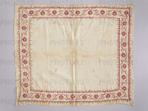 Church napkin. Napkin of white linen canvas edged with a band embroidered with silk and gold thread. Around the edges is a floral and vine motif framed at the top and bottom by a stylized clover ornament. The embroidery is single-sided, pierced; the gold thread on the left side has only a silk core and is unbraided. Dominant colors: magenta and gold. Density: 29 weft threads and 25 warp threads per 1 cm. 17th/18th century, Poland. Fabrics. Height 75 cm, width 63 cm.,  noted. Church paraments; used in Evangelical church furnishings; sacred art., A square piece of light-colored fabric with a decorative embroidered border; the central area is plain and slightly wrinkled with some faint spots and discoloration. The border features a floral vine motif in shades of pink and gold, forming an inner rectangular frame and an outer margin that mirror each other. The flowers are stylized and repeated along the edges, connected by curving stems and small rounded decorative elements. The fabric edge...