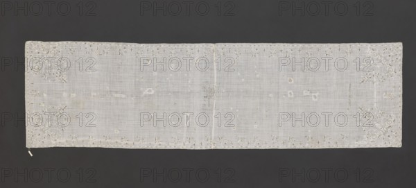 Church napkin. Napkin of white, thin, sparsely woven plain-weave batiste, embroidered with silk thread and metal thread on a silk base; fabric sewn together in the center. Embroidered motifs of small floral sprigs and stars along the long edges; corners with larger stylized flower bouquets emerging from a single stem. Embroidery mainly with white threads, details in metal threads. One end bears an embroidered inscription: Katarzyna z Obory Oborska / AD. 1636. In the center, within a frame, a partially illegible inscription: BODY M.../.../AND MY TRUE BLOOD/IEST..../WHO WILL FEED. Flat embroidery with silk yarn and pierced metal threads. Stitches: satin and cord. Metal threads: cut copper-gold plate and silver-gold plate woven on a silk core. 17th century, Poland. Dimensions: height 236 cm, width 64 cm. Function: church parament napkin. Subjects/motifs: flowers, leaves, plant ornaments, sacred art., A rectangular, light-colored sheer cloth with delicate woven texture lies flat against a ...
