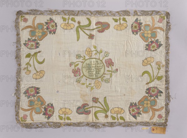 Church napkin, gift; church paraments; flowers; Evangelical church fittings; Sielec Swietokrzyskie Voivodeship, Staszów County; leaves, plant ornaments, sacred art, churches and chapels fittings. Church napkin possibly vellum? made of white linen batiste embroidered with multicoloured silk threads. In the center, in a circle surrounded by a wreath of large flowers, an inscription: TOC/ IEST ON CHLEB/ ZYWY. WOTY NIEBA/ ZTAPIEJ Y DAJE ZYWY/ WOT WWIATU/ RP 1686/14 KWIET. Along the edges are large flower sprigs, including irises. Edges trimmed with gold bobbin lace. Dominant colors: blue, pink, sand, and gold. Batiste: 22 warp and weft threads per meter. Double-sided flat embroidery, pierced, very fine stitches. Embroidery in silk yarn and threads with a metal braid in silver and gold on a silk base; flat and split stitches. Date: 1686, Poland. Materials: fabrics. Height 63 cm, width 86 cm., A rectangular piece of fabric with a pale cream background bordered by a textured metallic lace tri...