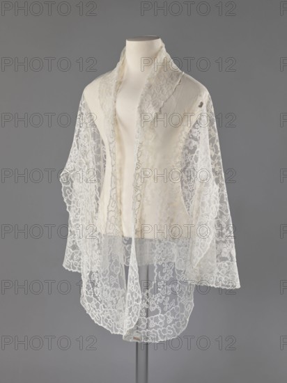 Cape, lace, message provenance, clothing accessories, women's clothing, fashion, capes, 19th century, Europe, clothing accessories, length 75 cm, width 192.5 cm, A display mannequin draped with a delicate lace shawl or scarf, the fabric appearing sheer and intricately patterned with floral and looping motifs; the garment has a soft, off-white to ivory tone with translucent sections showing the lace's openwork, and the mannequin is a pale cream color; the background is a smooth, mid-gray color, and a slim, darker gray stand is visible beneath the mannequin.