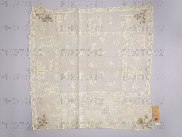 Tablecloth., Embroidered tablecloth: white embroidery on white mesh. In the center are projections of small floral sprigs. At three edges are motifs of trees and houses; at the fourth, widest edge, a wide twig motif. In the corners, four different floral or leafy sprigs are embroidered with gold thread in stitched stitches. Church paraments; sacred art; churches and chapels furnishings. 18th century, Poland. Fabrics. Height 65 cm, width 66 cm., A square lace cloth displayed flat against a pale gray background, predominantly off-white or cream in color with a few small areas of light brown decorative embroidery near some corners, featuring an open net-like center with scattered small floral motifs, a scalloped inner border and a wider outer border containing larger floral and geometric lace patterns, subtle folding creases visible, and a small rectangular tag attached near one corner.