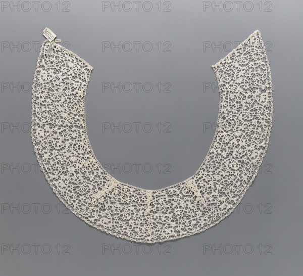 Collar;, Semicircular lace collar with elongated corners shape obtained using darts, decorated with floral ornaments and de brides type background with picots. 17th–18th century, Italy. Clothing accessory; lace. Width 15 cm, length 150 cm. Repossession, A crescent-shaped lace collar made of off-white thread with an open, intricate floral and looped pattern lies flat against a smooth gray background; the lace has a scalloped outer edge and a straighter inner edge, and there is a small cluster of off-white and slightly darker beige tags pinned near one end.