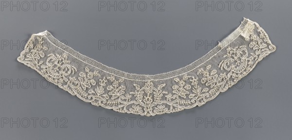 Collar, 19th century, France, band-shaped, equal width, arched with slightly serrated outer edge following the ornament forms. Ornament of floral motifs placed on a mesh background. Materials/technique: lace; function: clothing accessory. Dimensions: width 5.2 cm, length 37 cm., A delicate semicircular lace collar in off-white with intricate floral and scrollwork embroidery laid flat against a muted gray background, showing a mesh ground with denser embroidered motifs along the lower edge and a narrow patterned band along the inner curve; the lace features loops, leaves, and flower shapes in off-white thread with fine netting between motifs, and the background appears uniformly gray.