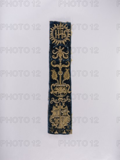 Chasuble pillar, embroidery, coats of arms, liturgical vestments, Sreniawa coat of arms, Slepowron coat of arms, plant ornaments, church paraments, sacred art, churches and chapels furnishings. Chasuble column embroidered on dark blue velvet over a thick linen canvas. At the top, in a radial medallion, the inscription IHS; below, a vase with stylized flowers; at the bottom, a four-field shield with the coats of arms: Slepowron, unrecognized, Brodzicz, Szreniawa. Above the shield the letters Z and K, below the shield E and V …Koscielecki Episcopus Vilnensis, see. at Niesiecki, J. Ch., perhaps Varmiensis?, MJ. Embroidery: laid metal threads on bases of various heights made of linen threads. Metal threads in gold and silver: cut plate, plate braided on a silk thread, bullion, drawn wire, attached with linen and silk yarn. Embroidery with silk yarn in flat, split, and banner stitch. E. Soszko; 17th century, Poland. Materials: fabrics. Dimensions: length 90.5 cm, width 18 cm., A long narrow...
