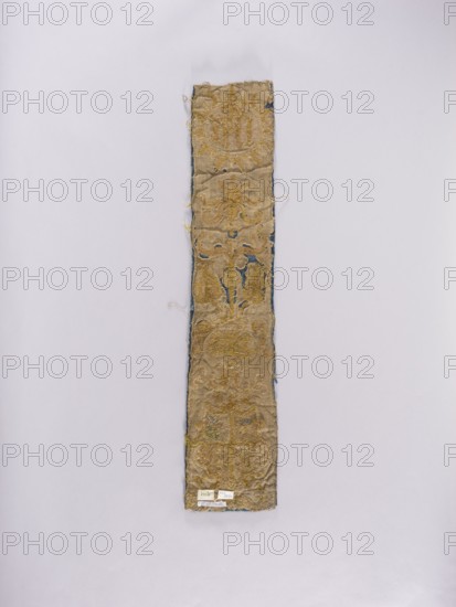 Chasuble pillar, embroidery, coats of arms, liturgical vestments, Sreniawa coat of arms, Slepowron coat of arms, plant ornaments, church paraments, sacred art, churches and chapels furnishings. Chasuble column embroidered on dark blue velvet over an underlying thick linen canvas. At the top, in a radial medallion, the inscription IHS; below, a vase with stylized flowers; at the bottom, a four-field shield with the coats of arms: Slepowron, unrecognized, Brodzicz, Szreniawa. Above the shield the letters Z and K, below the shield E and V …Koscielecki Episcopus Vilnensis, see. at Niesiecki, J. Ch., perhaps Varmiensis?, MJ. Embroidery: laid metal threads on bases of various heights made of linen threads. Metal threads in gold and silver: cut plate, plate braided on a silk thread, bullion, drawn wire, attached with linen and silk yarn. Embroidery with silk yarn in flat, split, and banner stitch. Attributed to 17th century, Poland. Materials: fabrics. Dimensions: length 90.5 cm, width 18 cm....