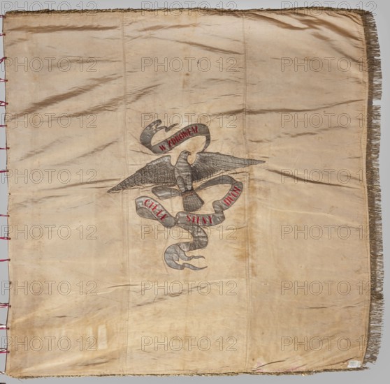 Banner of the Sokól Gymnastic Society, Double-sided banner, fabrics, 1906. Front: blue with red grosgrain, three-field coat of arms under a crown—top right: White Eagle; left: Pogon; below: Angel with sword and shield coat of arms of Kiev Voivodeship. Embroidered inscription: 1906/ PTG Sokól w Kyjowie. Reverse: white/beige background with a silhouette of a falcon with spread wings against a flowing silver ribbon; ribbon bears embroidered red-thread inscription W ZDROWEM at the top and IELE SILNY DUCH at the bottom. Trimmed on three sides with gold bullion fringe. One vertical side has magenta ribbons threaded through metal rings for tying the flagpole 12 pcs.. Height 157.5 cm, width 157.5 cm. Origin: Kiev Kyiv, 1906., A large rectangular fabric with a worn beige background shows creases and discoloration, with a fringe along one long edge and stitched red loops along the opposite edge; near the center there is a stylized bird with outstretched wings in gray and darker gray tones, and a...