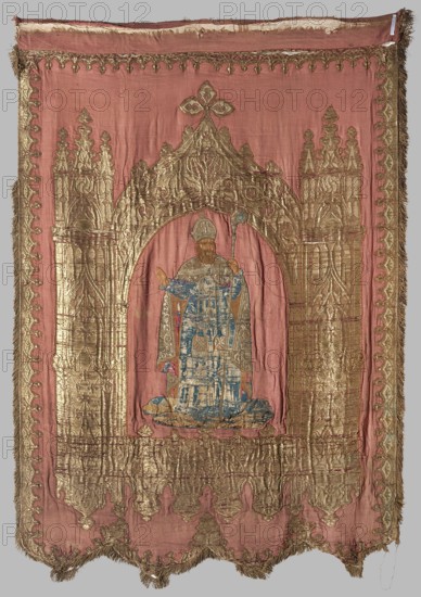 Church banner, 19th century, Poland. Church banner decorated with appliqué and embroidery. Made from fabric elements forming architectural decoration; figures sewn using the appliqué intarsia method onto a red one side and beige other background. Right panel: in the center of a neo-Gothic arcade between two towers, a figure of the Madonna and Child floating on clouds. Left panel: in a similar architectural frame with a woven pattern, a figure of a bishop in pontifical robes, identified as St. Nicholas. The Madonna panel is sand-colored; the bishop panel is cherry red. The Madonna figure is appliquéd from smaller fragments of velvet, patterned silks, paillettes, and beads. The banner’s edge is trimmed with gold fringe. The arcade fabric has a satin background, embellished and brocaded with metal thread. Materials: fabrics, embroidery; height 147 cm, width 102 cm., A rectangular textile panel in faded rose with a central archway rendered in metallic gold thread framing a standing robed f...