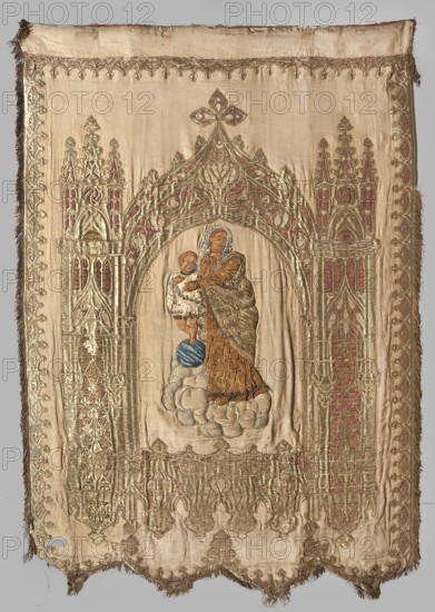 Church banner. Church banner decorated with appliqué and embroidery. Made from fabric elements that form the basis for architectural decoration for figures sewn using the appliqué intarsia method onto a red one side and beige other background. Right side: in the centre of the panel in the neo-Gothic arcade, between two towers, a figure of Mary and Child floating on clouds. Left side: in a similar architectural frame that is an already woven pattern, a figure of the bishop in pontifical robes St. Nicholas . Colors: the panel with the figure of Mary is sand-colored, the panel with the bishop is cherry red. The figure of Mary is appliquéd from smaller fragments of velvet fabrics, fragments of patterned silks, paillettes, and beads. The banner's edge is trimmed with gold fringe. The fabric with the arcade has a satin background, embellished and brocaded with metal thread. 19th century, Poland. Materials: fabrics; height 147 cm, width 102 cm., A rectangular embroidered textile panel with fr...