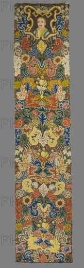 Tapestry, Tapestry embroidered in wool and silk on linen canvas. In the upper part, within a decorative cartouche, is the bust of a nobleman King Jan III Sobieski? with a mustache and shaved hair, wearing a zupan and delia with an ermine collar. Around it are dense scrolls of large leaves, flowers, and fruit. No border. Vivid colors: brown background, sapphire blue, blue, red, pink, green, navy blue, white, and ochre. The plant motifs of the nine fabrics comprising this set do not differ from each other. Stylized leaves, flowers, and fruit fill the entire surface. The composition unfolds on both sides of the axis, creating a symmetrical division of the decoration, similar to large-pattern silk upholstery fabrics fashionable in the late 17th and early 18th centuries. Minor differences include small animal silhouettes which enrich the decoration. All fabrics are decorated with the same fruit: plump bunches of black and white grapes, yellow apples, and dark red cherries. Vivid colors, bro...