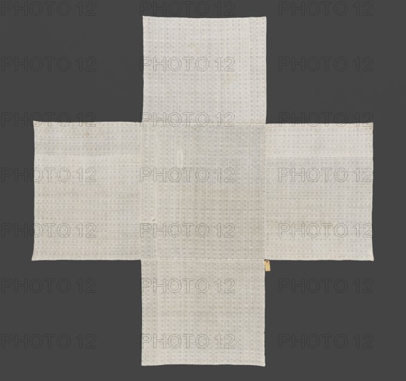 Doily, gift, church paraments, Evangelical churches, Sielec Swietokrzyskie Voivodeship, Staszów County, Consistory of the Evangelical Reformed Church provenance, Evangelical church Sielec furnishings. Doily sewn from five rectangular pieces of fabric forming a cross. The fabric is white, thin, with a pattern of alternating stripes: a zigzag snake motif with drops in the bends; patterns of twigs with pears ; between the twig patterns small squares with a sparser weave. The fabric has a tighter weave between the stripes. 18th century, East, fabrics; height 260 cm, width 257 cm., A light-colored fabric arranged in a cross-like shape against a dark gray background, composed of a central rectangular panel with a few rectangular panels extending from each side, all showing a subtle repeating textured pattern and slight variations in off-white and pale gray tones; a small tan tag is attached near one edge.