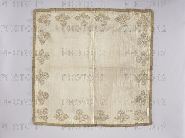 Velum, embroidery, church paraments, floral motifs, Henryków Heinrichau. Flowers, leaves, plant ornaments; sacred art; churches and chapels furnishings. Velum or church cloth of white linen batiste, embroidered along the edges with floral bouquet motifs in gold thread. In the center is an embroidered inscription IESUS, above which a small cross. Around the edges are stylized Persian-style flower bouquets. In one corner are embroidered the letters HHGS. Trimmed with gold bobbin lace with an interwoven ribbon motif late 17th century. A wide approx. 3 mm strip of gold thread is sewn onto the edges where the lace is sewn. Double-sided embroidery. Flat, pierced embroidery, satin stitch. The stitch direction is adapted to the shapes of the ornaments. Metal threads — a gold plate covered with multicolored patina, woven on a silk base. 17th century, Silesia; liturgical vestment. Height 74 cm, width 82 cm., A square cloth with a pale cream background bordered by a textured gold trim, showing a ...
