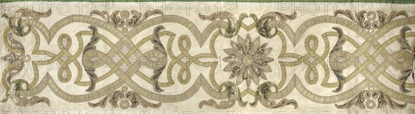 Fragment of a chasuble column, embroidery, rosettes, ribbon-and-pincer ornament. The column from the back of the chasuble is made of cream satin, onto which narrower and wider gold braids are sewn, creating a pattern of interwoven ribbons. A rosette and acanthus leaves are placed among them. The rosettes and leaves are embroidered with gold thread, sequins, and a slit. Early 18th century, Poland; fabrics; length 95 cm, width 26 cm., A horizontal decorative textile panel with a pale beige background featuring an intricate continuous knotwork pattern in shades of gold and muted olive, punctuated by a central floral rosette composed of layered petal shapes in grayish gold and darker brown tones; the design includes several looping bands and ribbon-like elements in gold with subtle pale pink textured inserts, flanked by symmetrical scrolling foliage motifs in green, brown, and gold, and accented by a few circular medallion shapes in golden and brown hues, with a narrow green border along t...