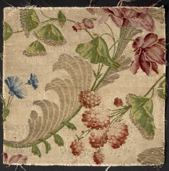 Fabric fragment, silk, 18th century France. Background: cannetillé white; pattern brocaded with colorful threads: celadon yellow, white, sky blue, paint, green-olive, light green, rose-burgundy, rose-orange, pale pink, red, gold lamella. Pattern: flower branches with umbrella-shaped leaves; flowers reminiscent of cornflowers, raspberries, and peonies. Dimensions: height 19 cm, width 19 cm., A woven fabric square with a textured beige background features a floral pattern in shades of green, red, pink, blue, and tan; there are several stylized leaves in light and dark green, clusters of rounded red and pink blossoms, a few elongated tan feathery shapes, and a small group of blue flower shapes, all arranged along curving green stems, with the fabric edges slightly frayed and a dark border visible around the square.