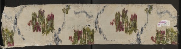 Fragment of fabric. Fabrics, fragments of silk fabrics, patterned fabrics, fabrics with preserved selvedge. Weave: background - Gros de Tour; liseré - white; pattern - brocaded with colored threads and the liseré effect with a white thread creates a subreport. Brocade threads: white, light and dark green, pink, sky blue, pale red, orange, plum. Pattern: floral bouquets connected with lace and chenille ribbons. Report: 43 x ? Edge width: 0.5 cm. France, Lyon probably 19th century; possibly produced in a Lyon manufactory 1820–1840. Height 20.5 cm, width 96 cm., A long rectangular piece of fabric with a light beige background shows a worn embroidered pattern featuring several vertical clusters of frayed threads in shades of green and pink, with accents of reddish tones, scattered across the surface; sinuous vertical and diagonal bands of frayed blue-gray thread run between the clusters, and there are a few areas of pale cream raised embroidery that form partial circular motifs; the fabric...