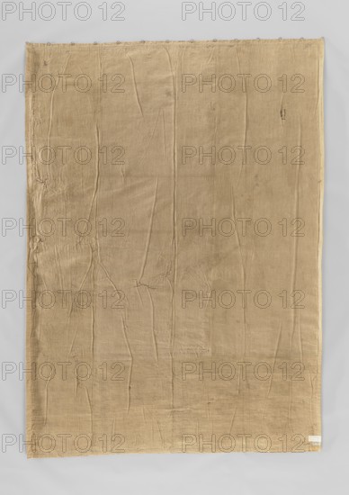 Figural tapestry, flowers, sheep, trees, bagpipes, landscapes, buildings, borders, folk musical instruments, hills, interior furnishings, interior decorations, scenes with a landscape background, pastoral and rural scenes, spindles, allegorical scenes. Most of the fabric has been preserved, missing the right border. In the center, against a forest landscape, a shepherd plays bagpipes while a shepherdess stands beside him with a distaff; sheep graze around them. Border with motifs of flowers, birds, and vases. Colors: blue, sand, brown, green, beige. 17th–18th century, Flanders. Materials: fabric. Height 281 cm, width 200 cm., A large rectangular piece of fabric hangs against a neutral light gray background, appearing tan to light brown in color with visible creases and folds across its surface; the fabric shows uneven texture with a few small darker spots and faint stains, and some areas along the edges display slight fraying and irregular stitching; a row of small metal rings runs alo...